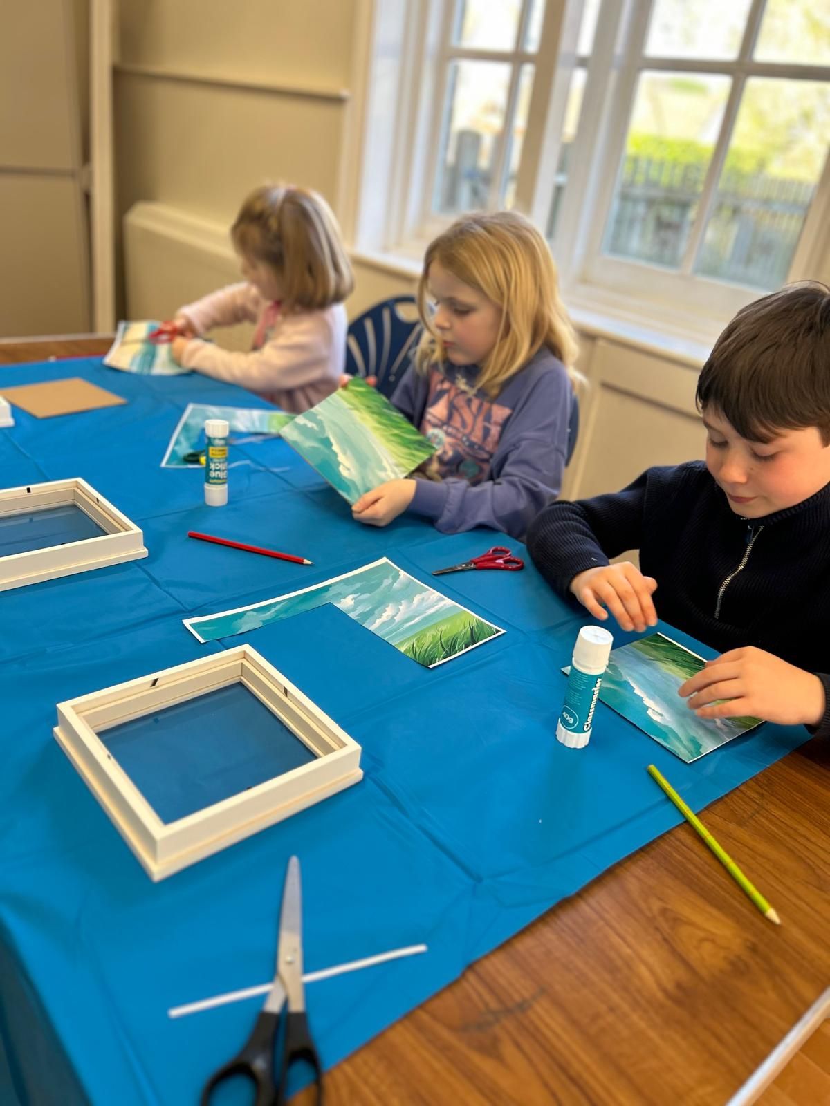 A group of children are sitting at a table making crafts  at Dragonfly crafts parties session.