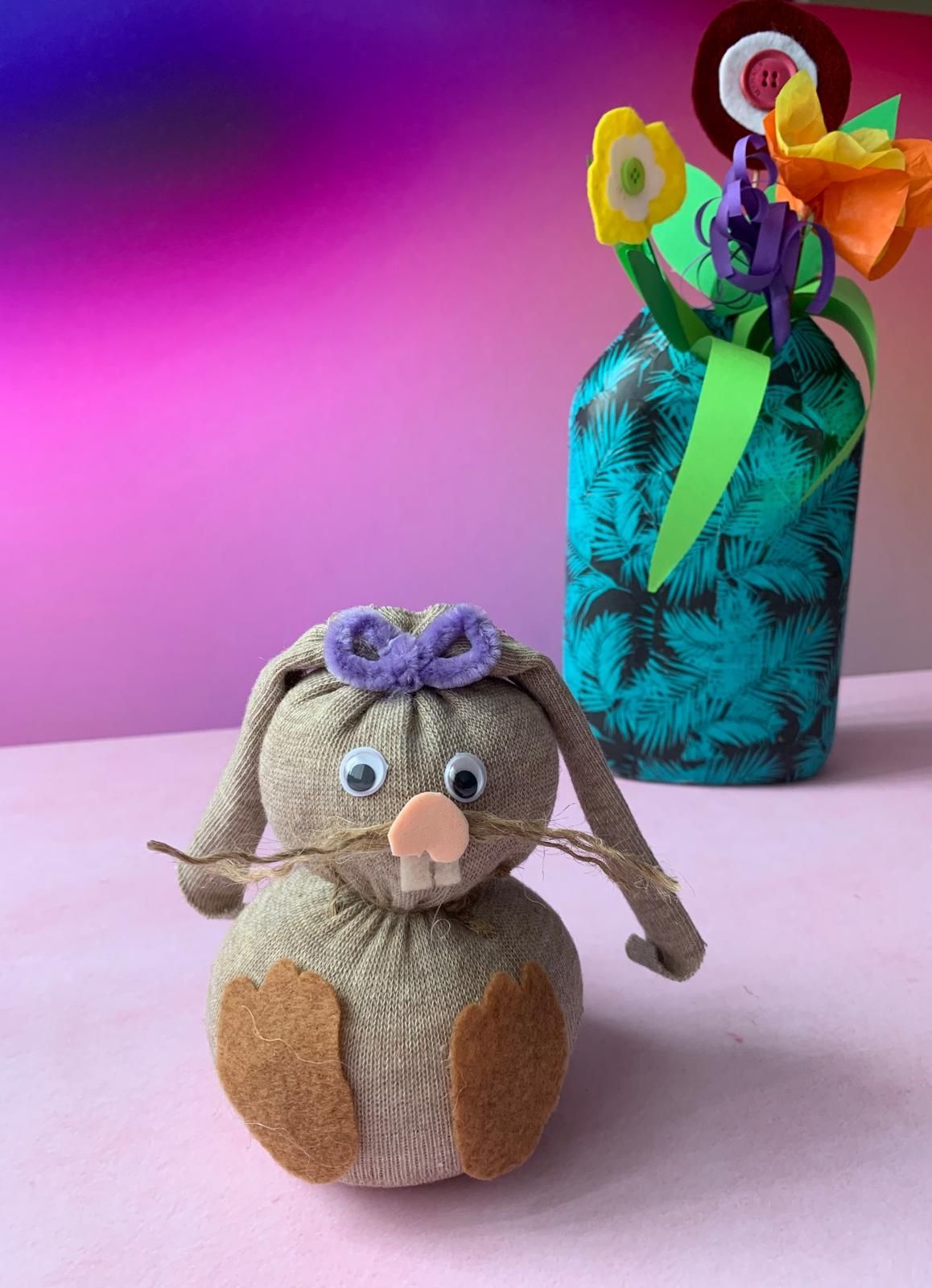 A stuffed bunny is sitting next to a vase of flowers for  Dragonfly craft parties