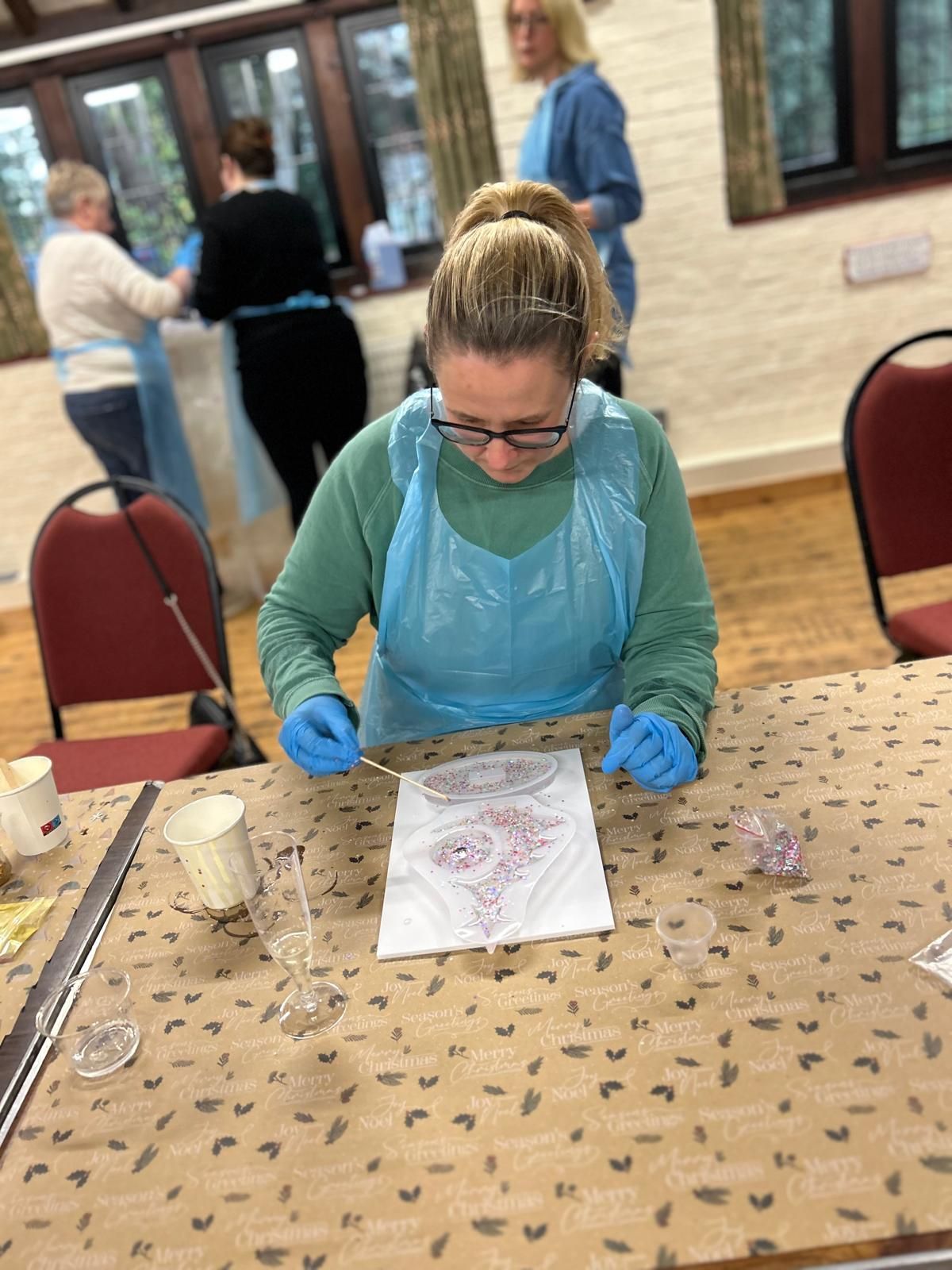 A woman is sitting at a table with a piece of paper at Dragonfly crafts party