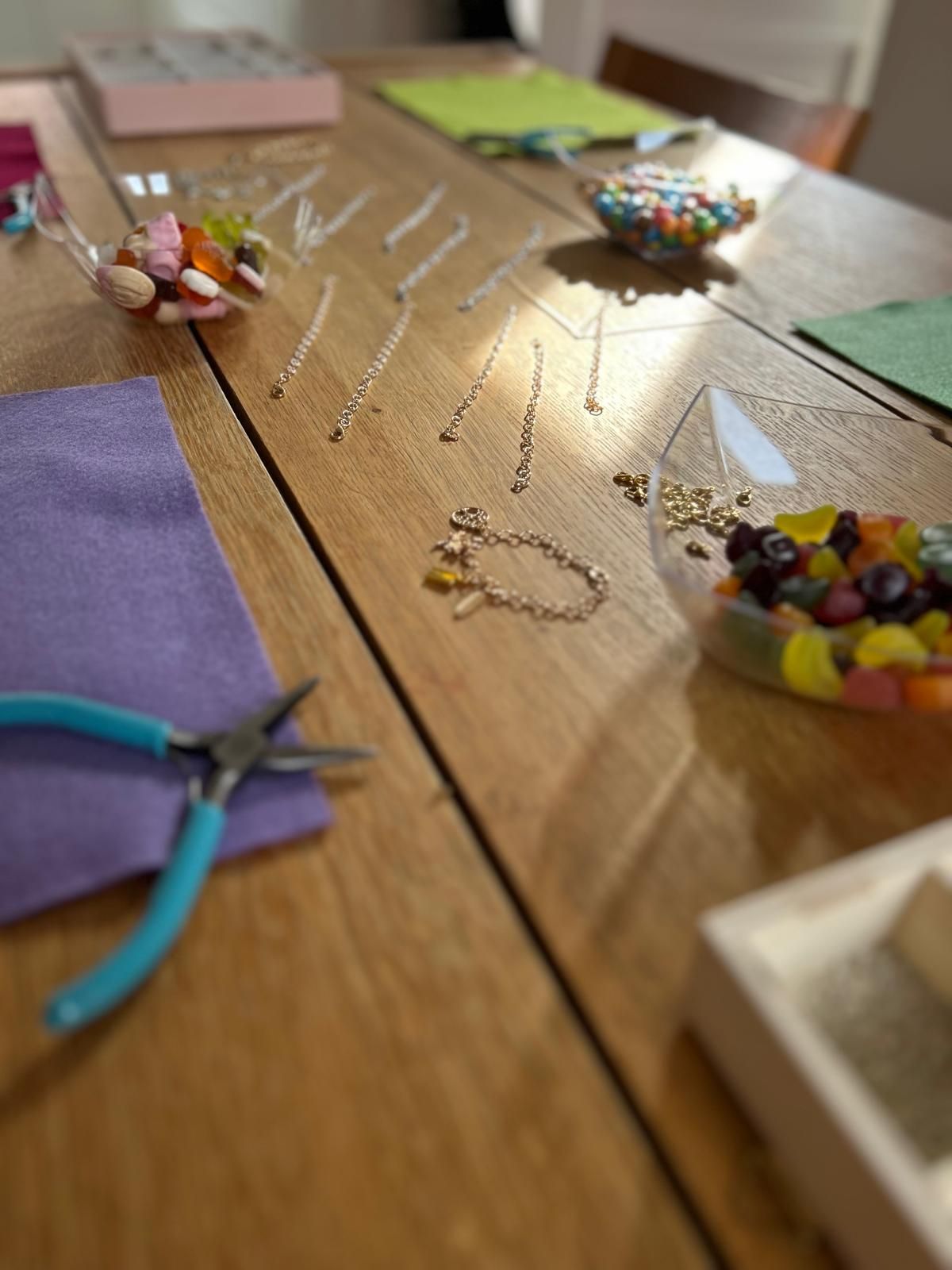 A wooden table with a lot of beads on it for charm party  at Dragonfly crafts parties