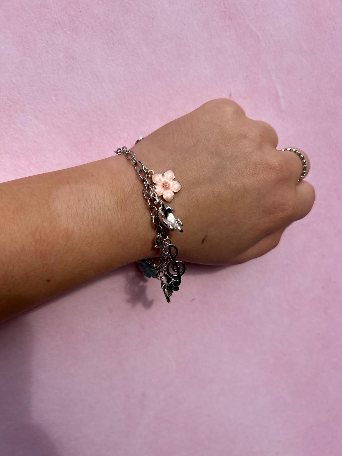 A woman wearing a bracelet with a pink flower on it for charm party  at Dragonfly crafts parties