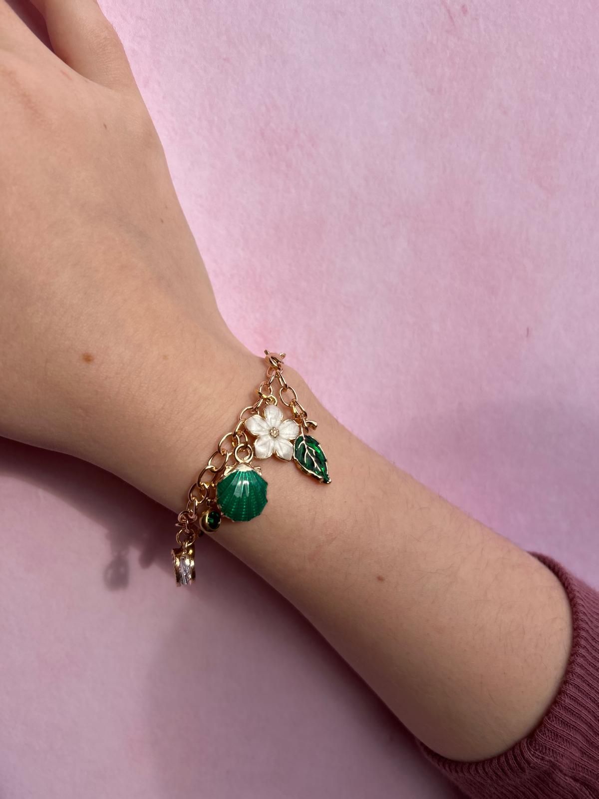 A person wearing a bracelet with green beads and a white flower for charm party  at Dragonfly crafts parties