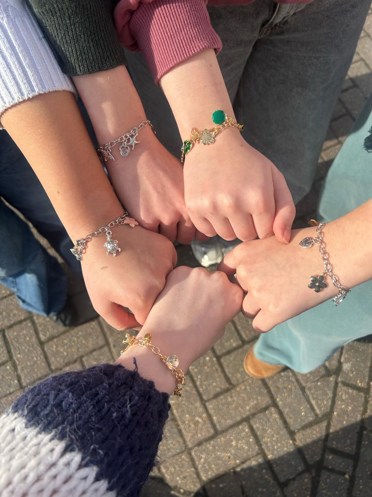 A group of people wearing bracelets on their wrists for charm party  at Dragonfly crafts parties