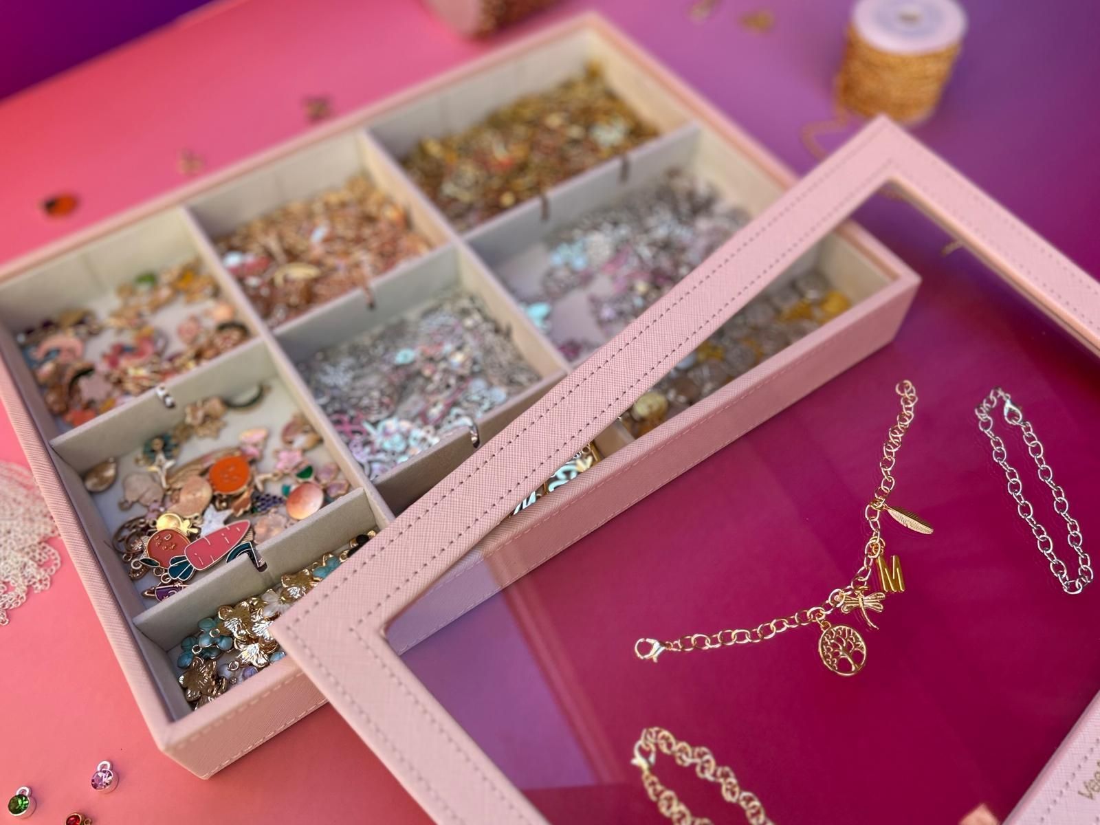 A pink jewelry box with a clear lid filled with jewellery for charm party  at Dragonfly crafts parties
