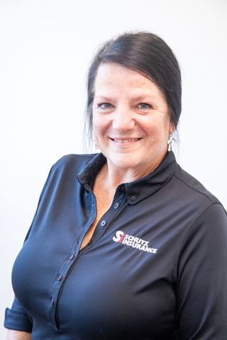 The woman is wearing a black shirt and smiling for the camera.