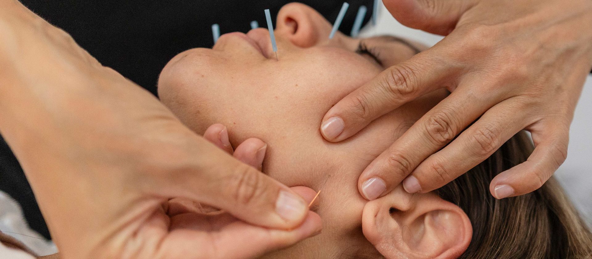 Hands massaging a person's face and ears during a relaxing treatment Hands massaging a person's face and ears during a relaxing treatment