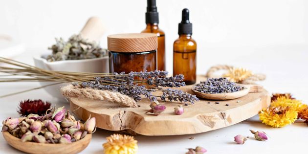 Herbal oils, dried flowers, and lavender arranged on a rustic wooden board with amber bottles Herbal oils, dried flowers, and lavender arranged on a rustic wooden board with amber bottles