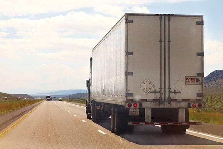 Un camión blanco circula por una carretera.