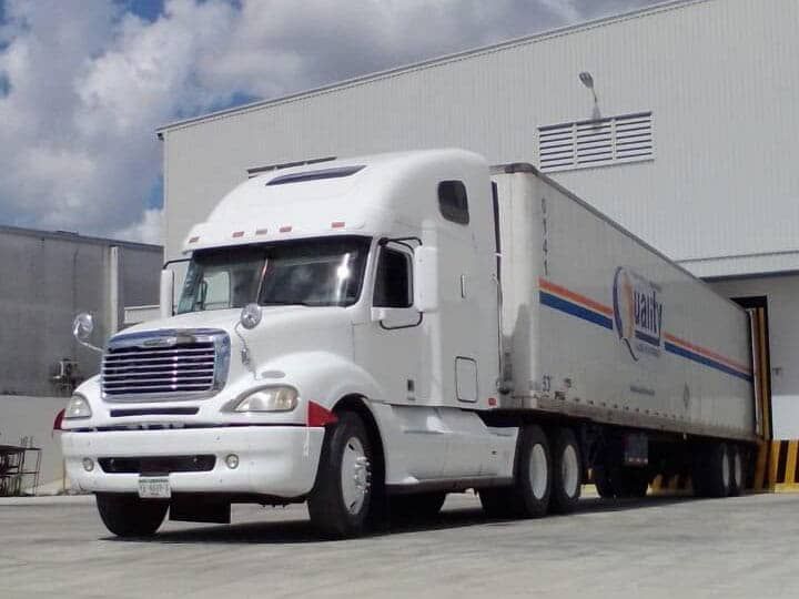 Un camión blanco está estacionado frente a un edificio