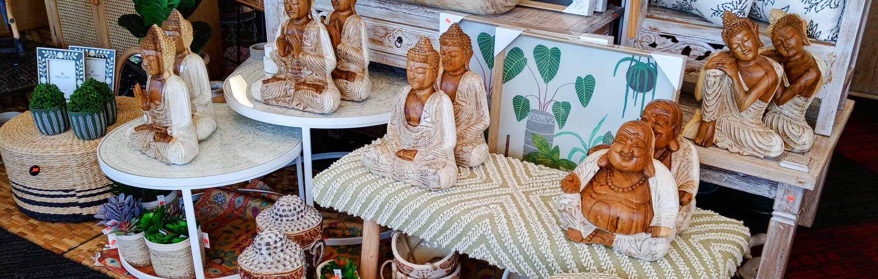 A bunch of statues of angels are sitting on tables in a room.