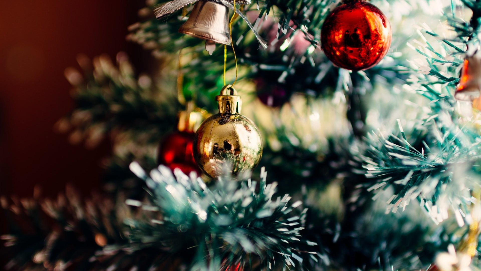 A close up of a christmas tree with decorations hanging from it.