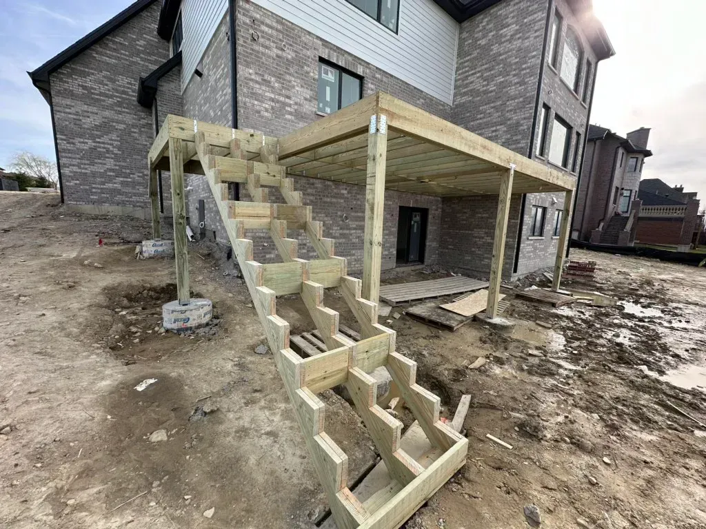 New house exterior with unfinished concrete steps and a raised porch under construction