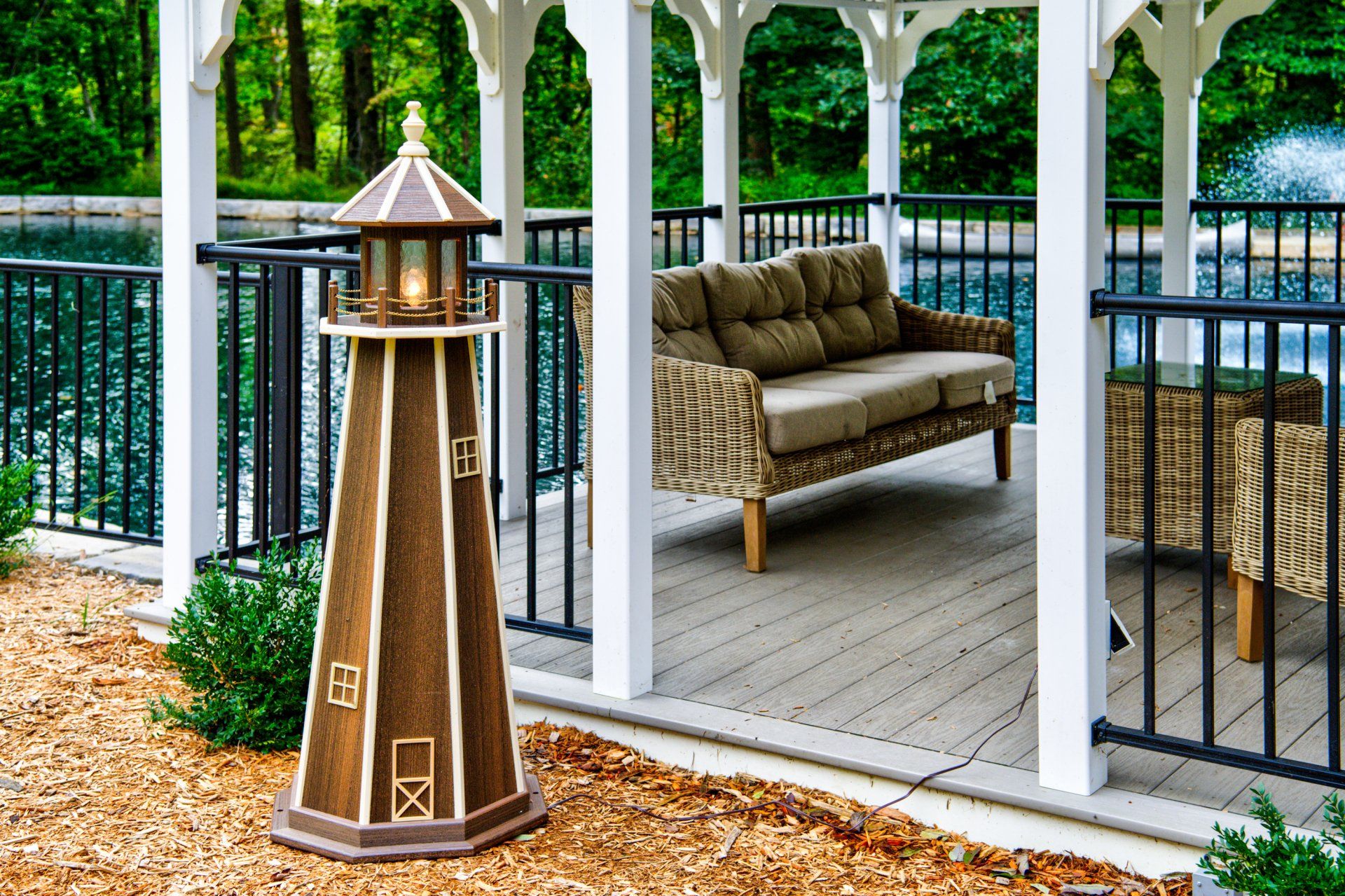 A lighthouse is sitting on a patio next to a couch.
