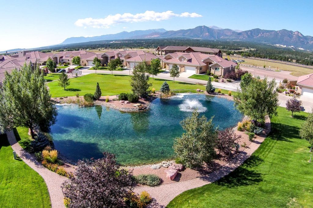 An aerial view of a lake in a park with mountains in the background.