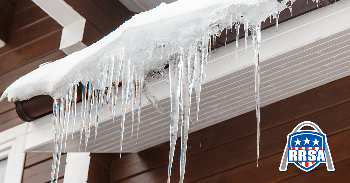 Ice dams hanging from a brown roof, with icicles.
