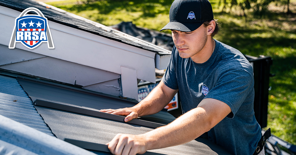 Roofer on a roof with hands on the metal. Wearing a hat and working in sunlight. RRSA logo in the corner.