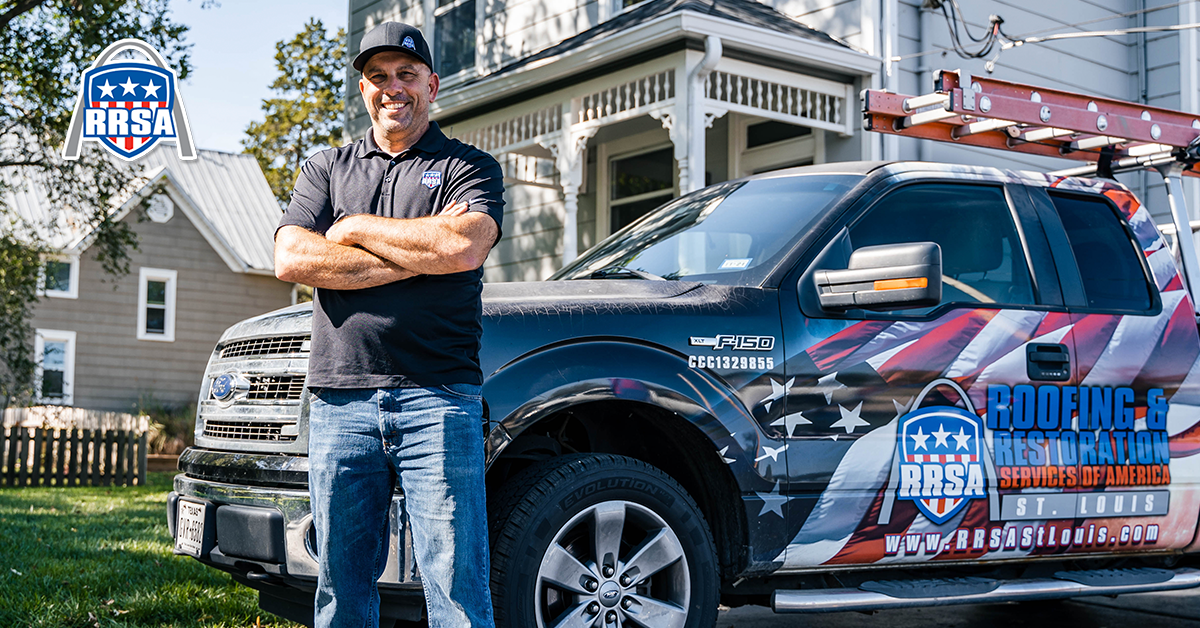 Man with arms crossed, in front of his company truck, in front of a house.
