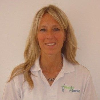 Woman with long blonde hair wearing a white polo shirt smiles in front of a white wall.