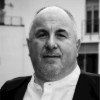 A black and white photo of a man in a suit and white shirt.