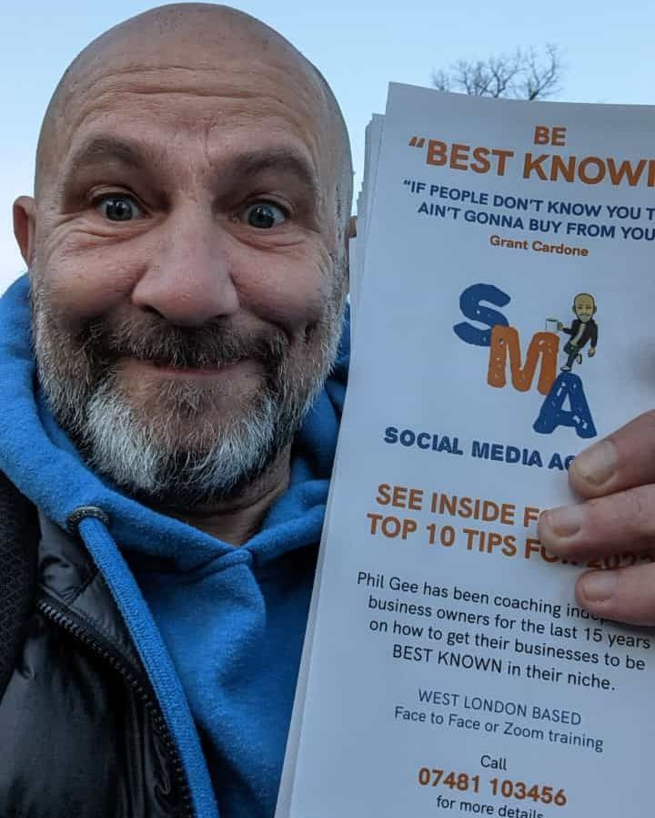 A man with a beard is holding a sign that says be best known