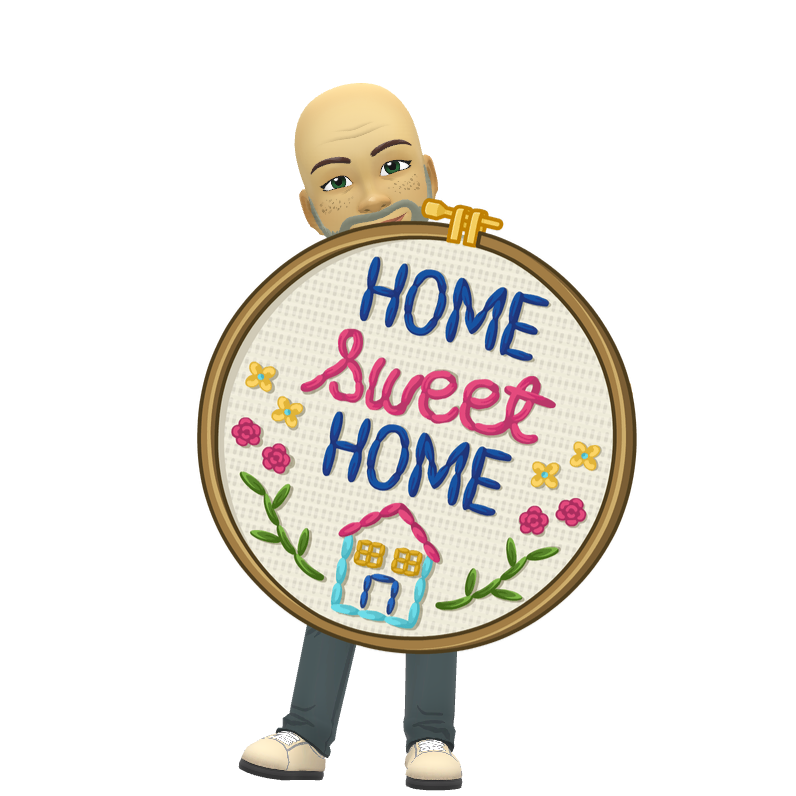 A man is holding a cross stitch hoop that says home sweet home.