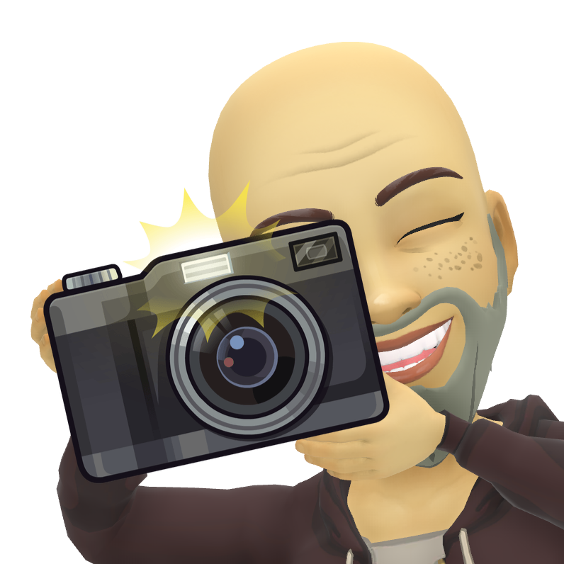 A bald man with a beard is taking a picture with a camera