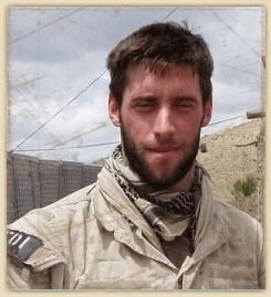 A man with a beard is wearing a scarf around his neck.