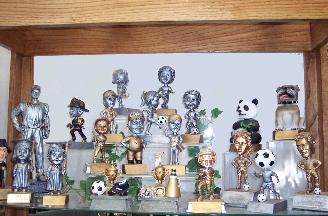 A group of trophies are sitting on a wooden table— Riverside, CA — Awesome Awards Western Trophy A group of trophies are sitting on a wooden table— Riverside, CA — Awesome Awards Western Trophy