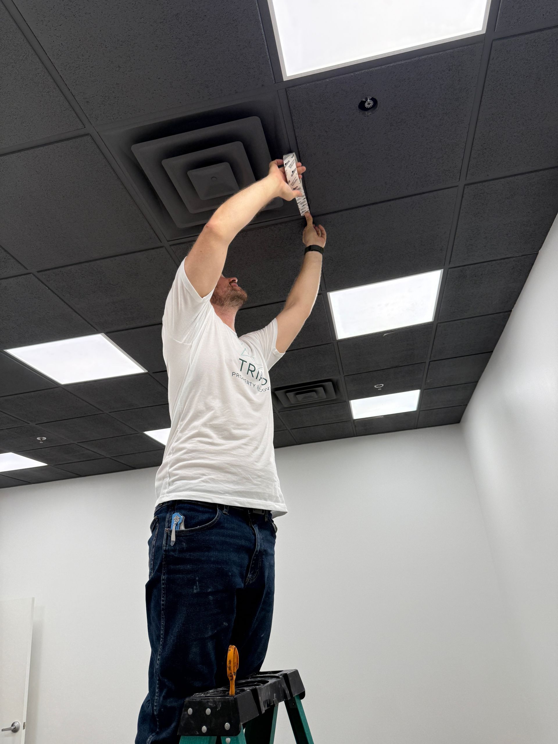 A person adjusting a ceiling in a room.