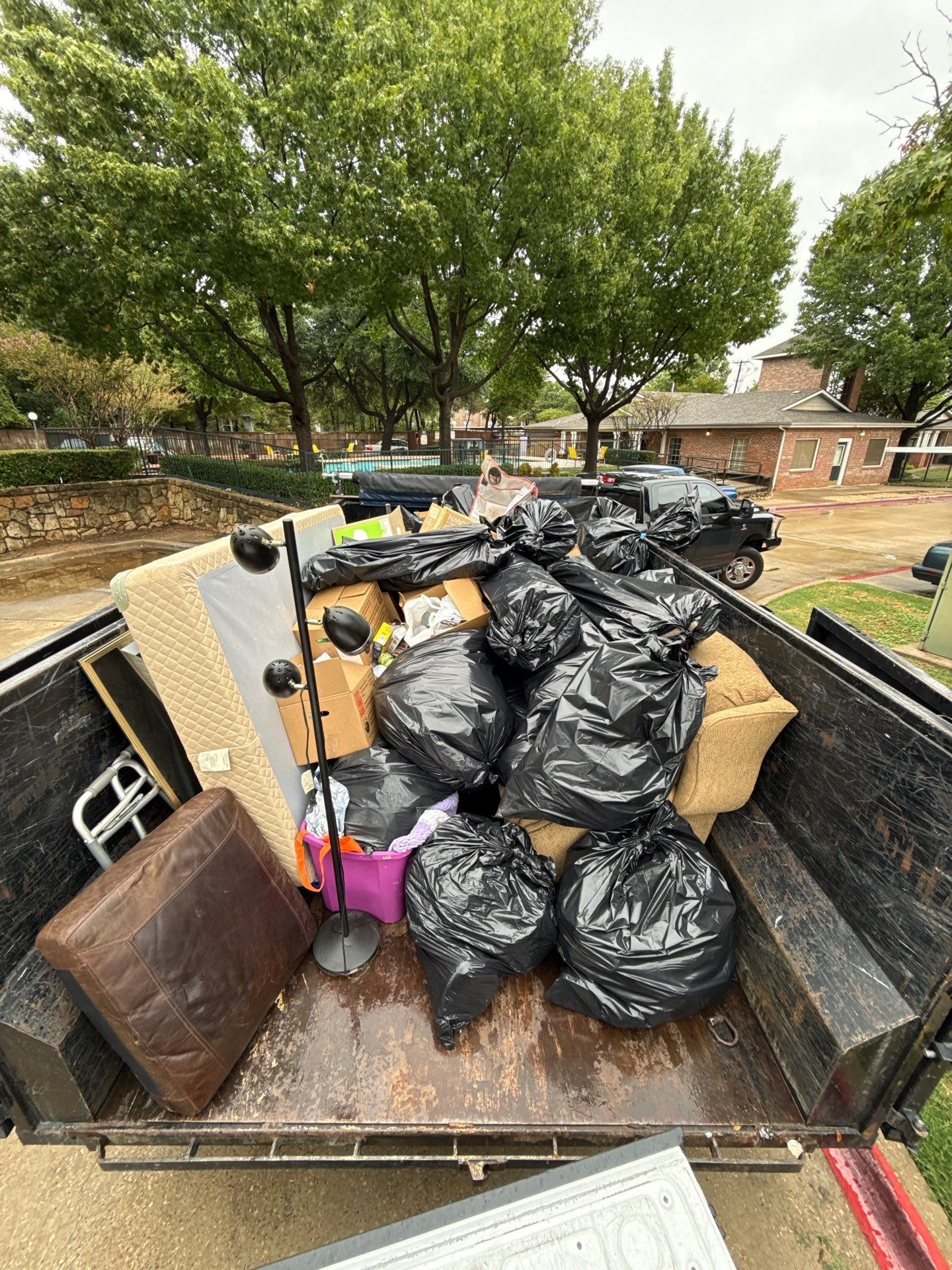 Trailer loaded with sealed black bags and items removed from the apartment