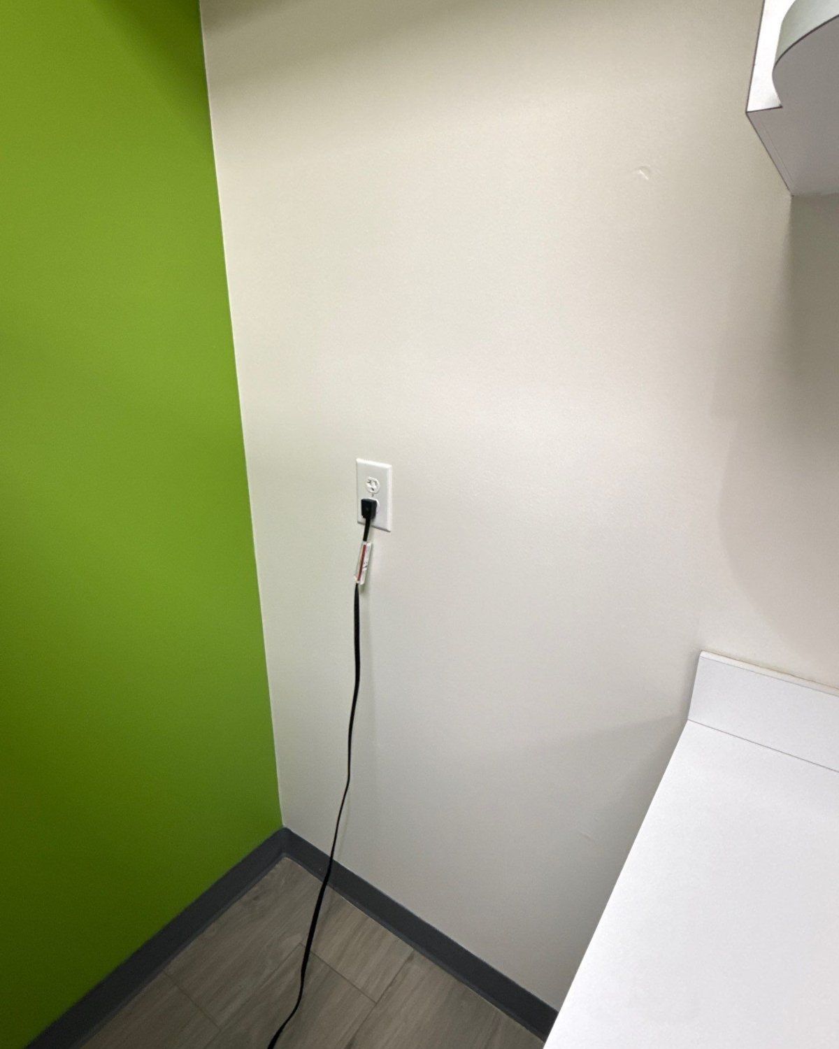 Clean white wall behind a refrigerator after mold remediation in a Plano office