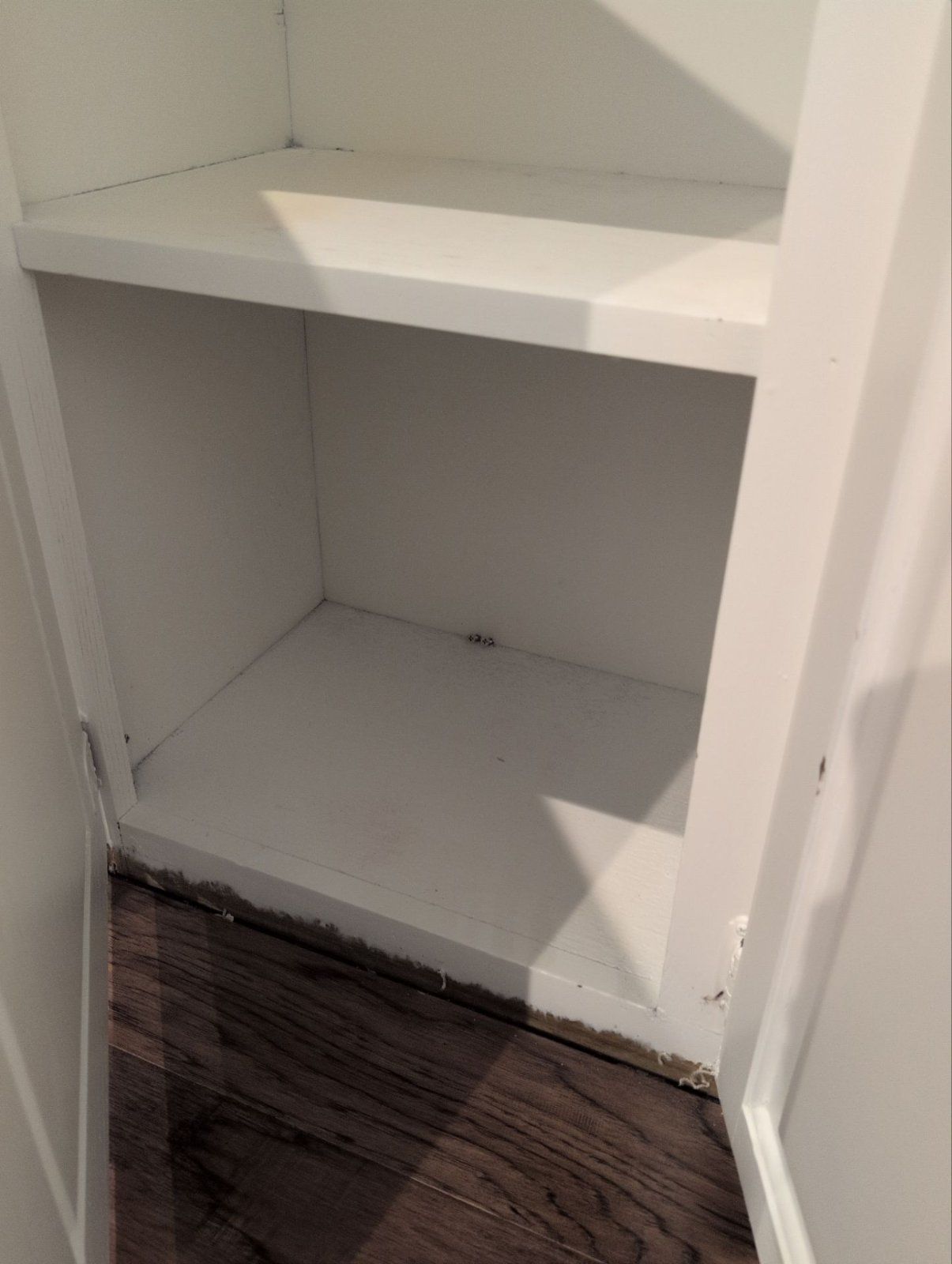 Built-in cabinet with water damage along the bottom edge after a water heater leak