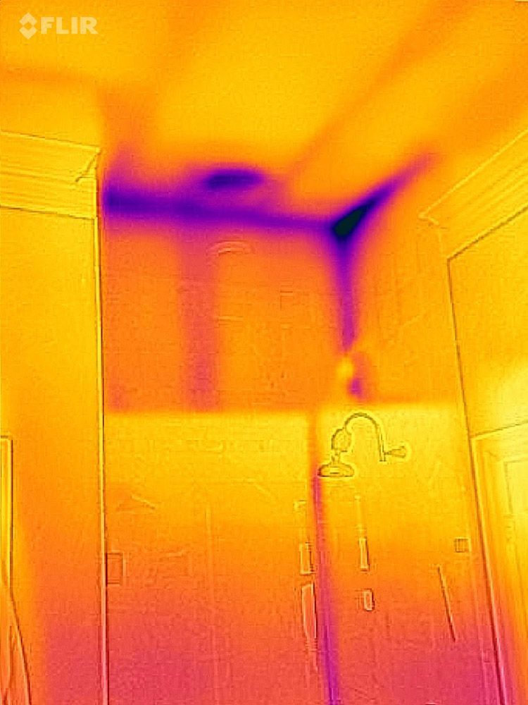 Thermal image of a room interior, revealing a cold spot on the ceiling and walls, due to moisture.