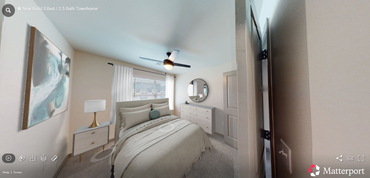 A bedroom with a large bed , nightstands , lamps and a painting on the wall.