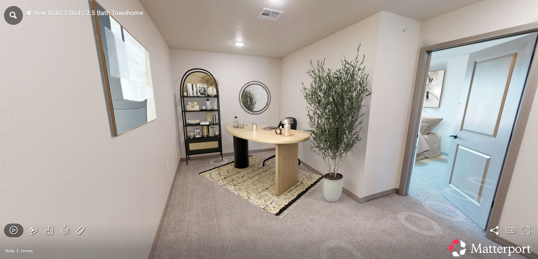 Bright entryway with carpet, console table, mirror, wall art, shelving, and a large potted plant.
