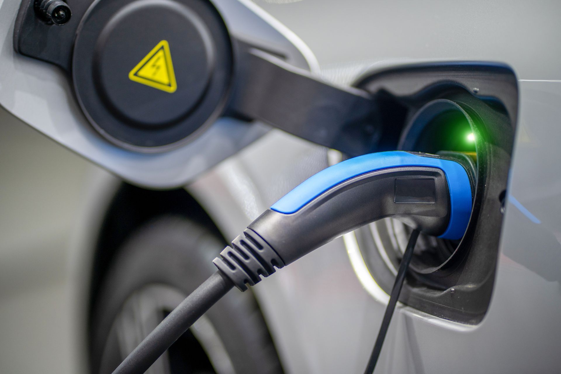 An electric car is being charged at a charging station.