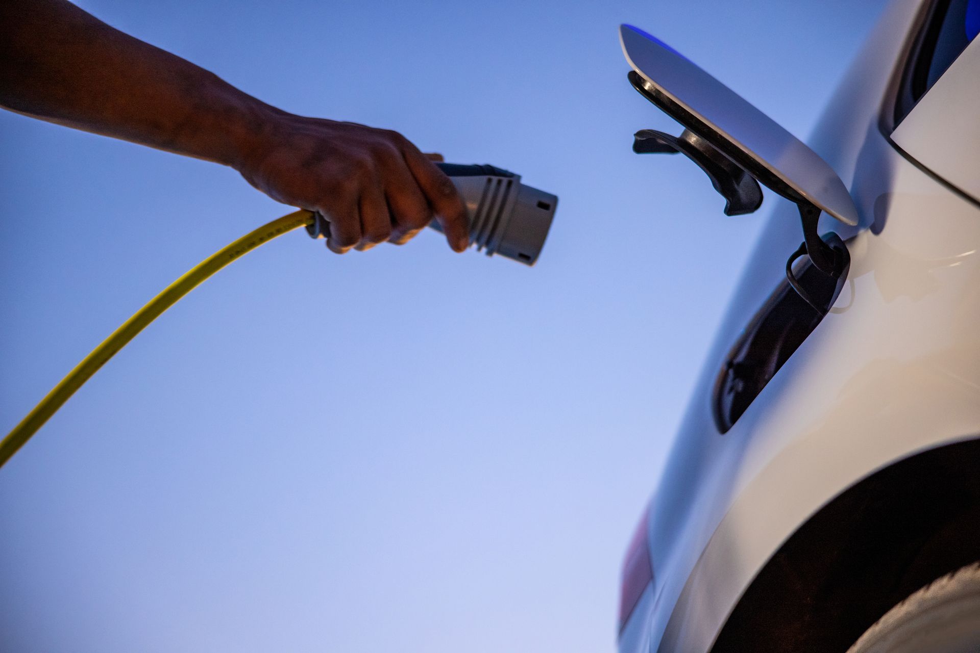 A person is charging an electric car with a charger.