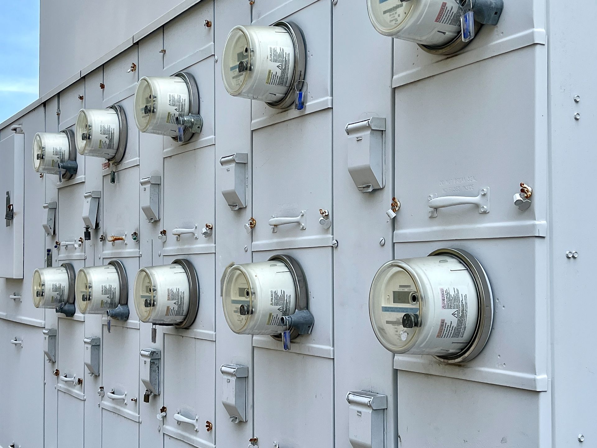 A row of white electrical meters on a wall