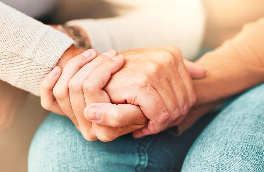 A close up of a person holding another person 's hand.