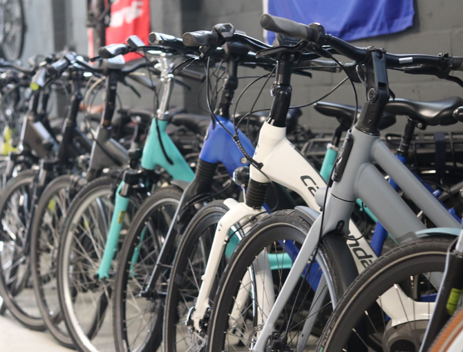 Fietsen tentoongesteld in een winkel, in diverse kleuren zoals turquoise, blauw, wit en grijs.