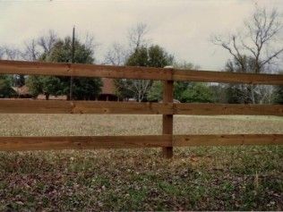 Wooden fence in front of a grassy field