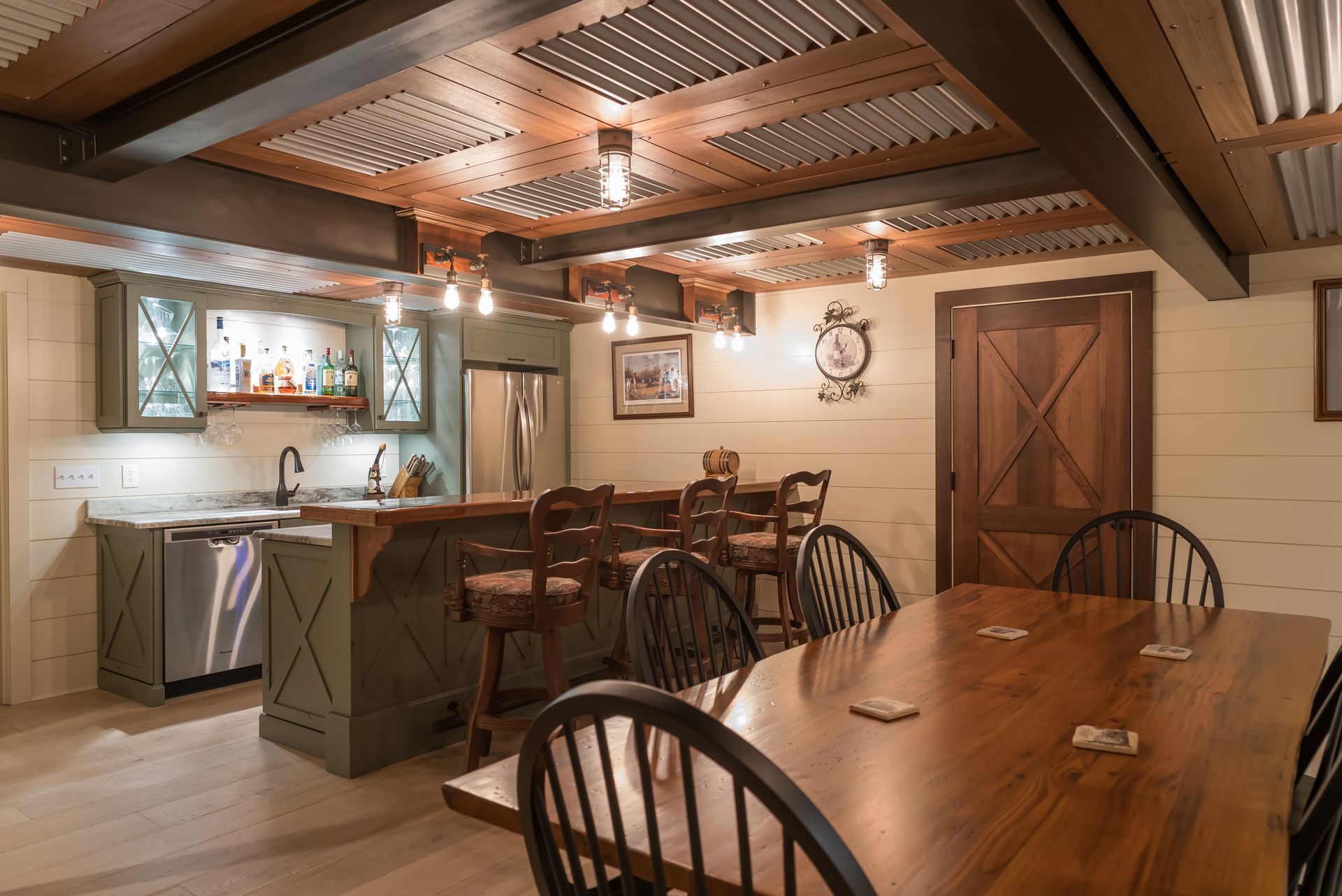 Warm rustic dining room with wooden tables, chairs, and a small kitchen bar under exposed beams