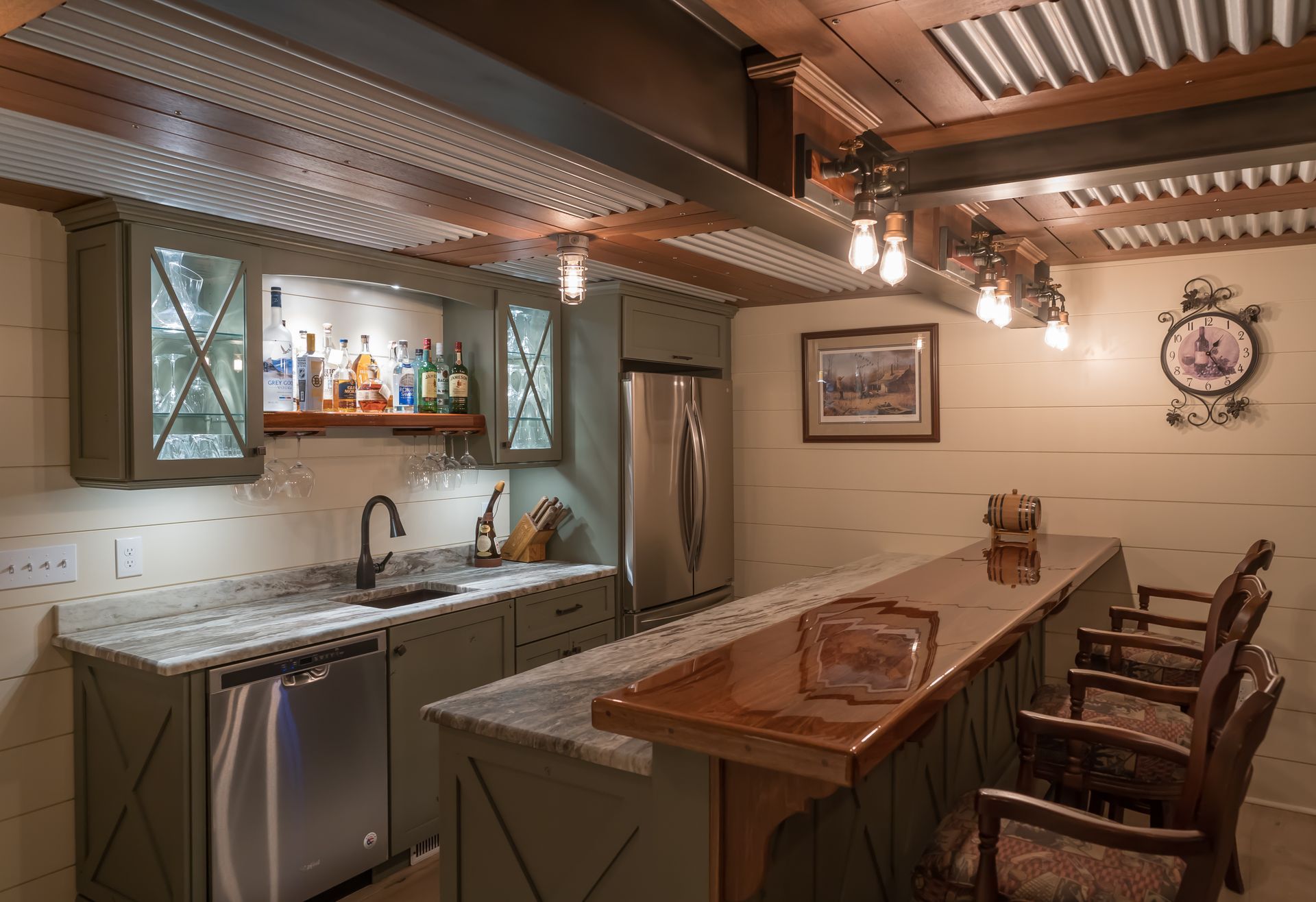 Modern kitchen with island, stainless appliances, warm lighting, and a dining table with chairs.