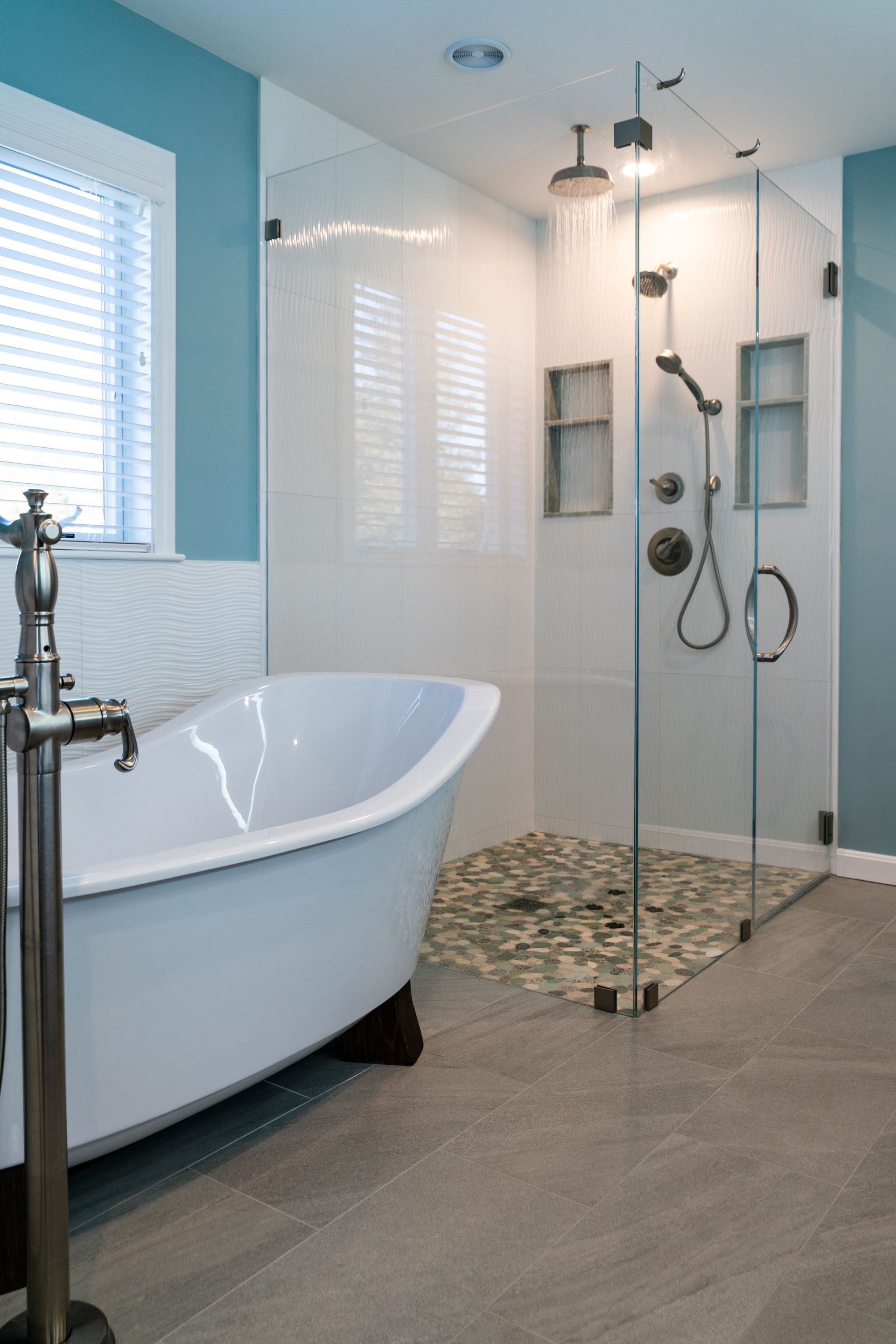Modern bathroom with freestanding tub, glass shower, and tiled floor
