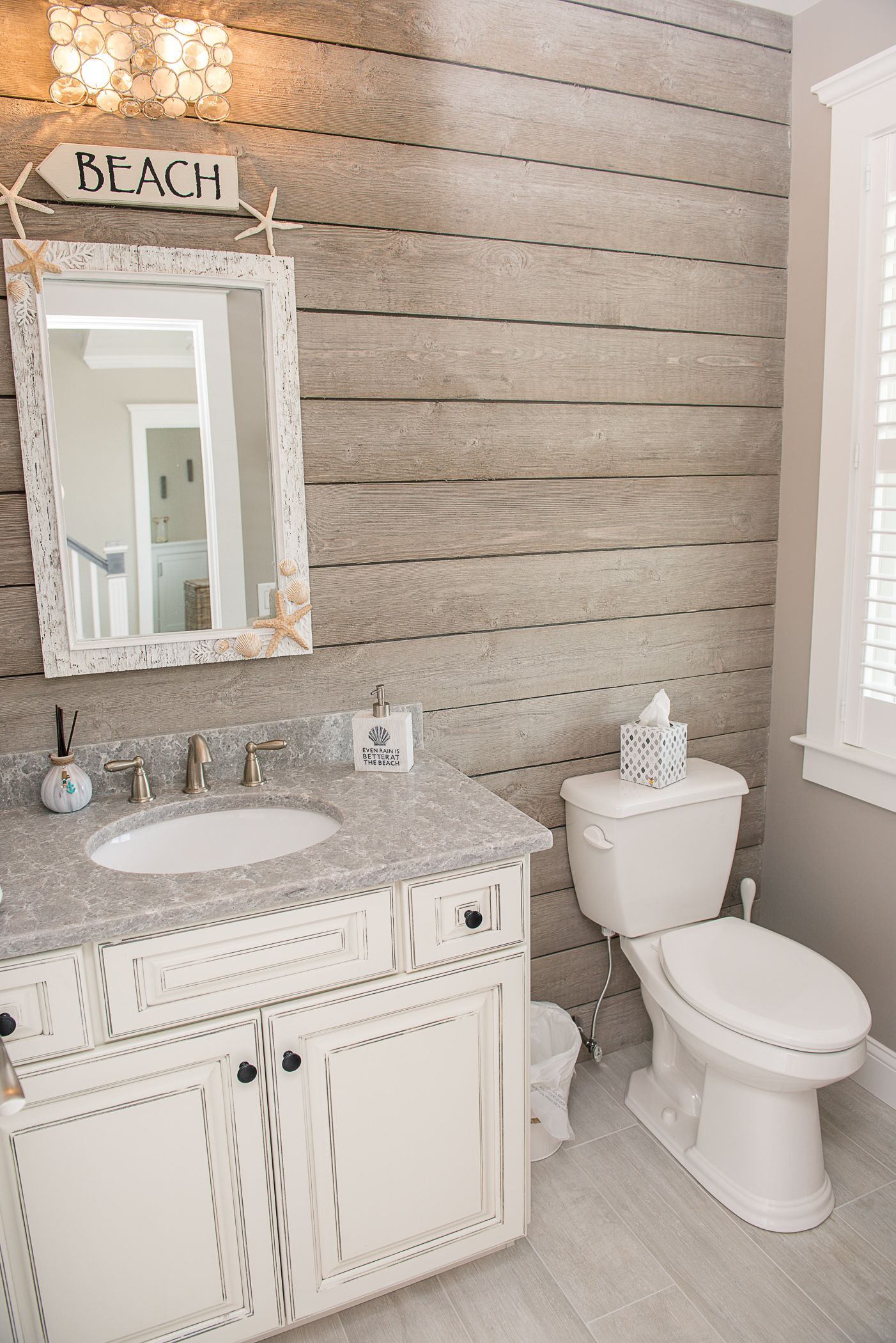 Elegant bathroom with white vanity, ornate mirror, and toilet against a textured beige wall