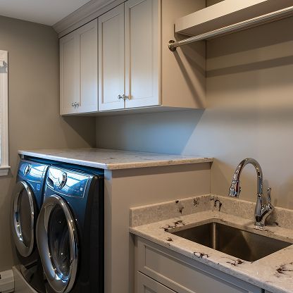 Laundry room with front-load washer and dryer, white cabinets, a sink, and a hanging rod.