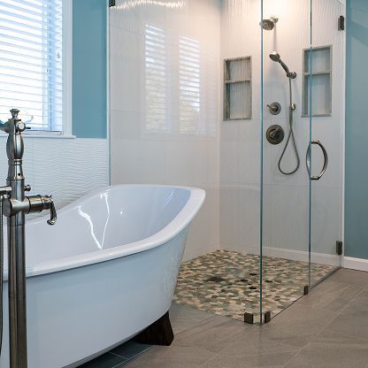 Modern bathroom with a freestanding tub, glass shower, and mosaic tile floor