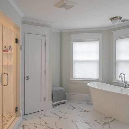 Bright white bathroom with marble floor, soaking tub, glass shower, and two windows with blinds