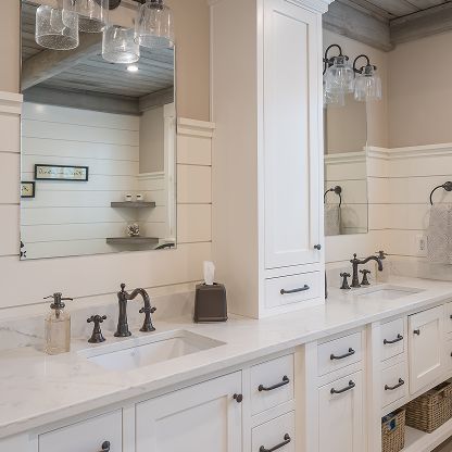 Bright white bathroom vanity with two sinks, dark bronze faucets, large mirror, and soft glass pendant lights