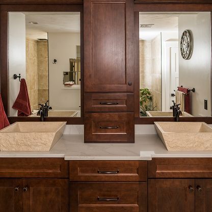 Double vanity bathroom with wood cabinets, beige sinks, and large mirrors